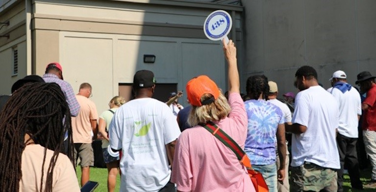 people at a tax sale bidding at auction